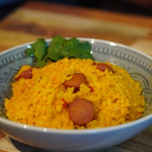Bowl of yellow. rice with sausage arroz con salchichas