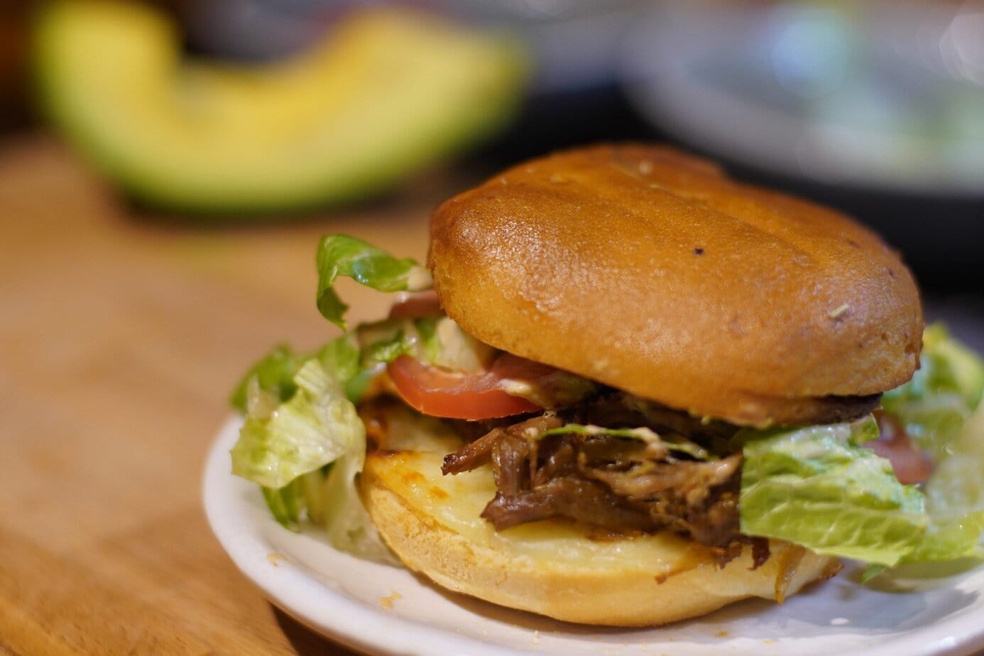 Picture of a peril Puerto Rican sandwich with a slice of avocado on the background.