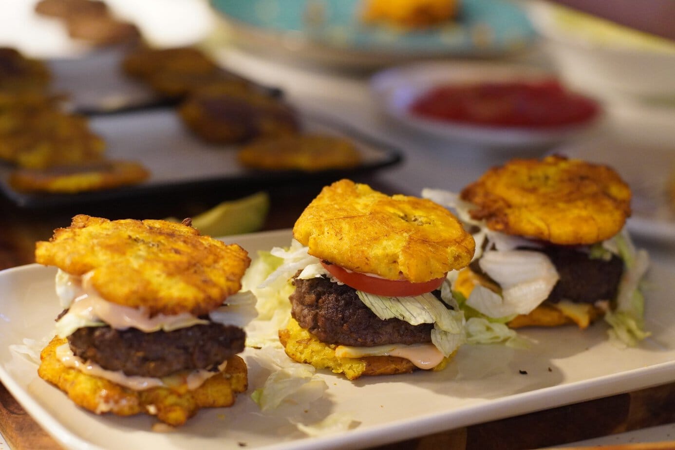 3 Jibaritos sliders served on a plate with other plates in the back ground