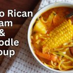 Top view picture of bowl with Sopas de Jamon with title on the left that says Puerto Rican Ham and Noodle soup.